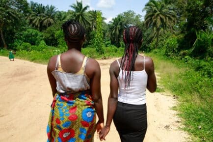 Cousins Kpemeh, 18 and Kuji, 19 walk home hand in hand in Kailahun, Sierra Leone